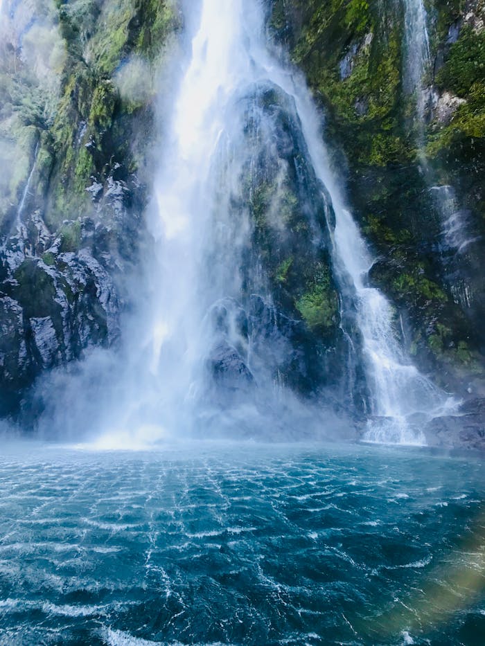 A stunning waterfall cascading into a turquoise pool in Southland, New Zealand.