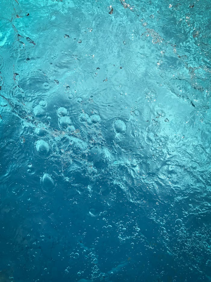 Detailed shot of bubbles in blue water creating a textured background.