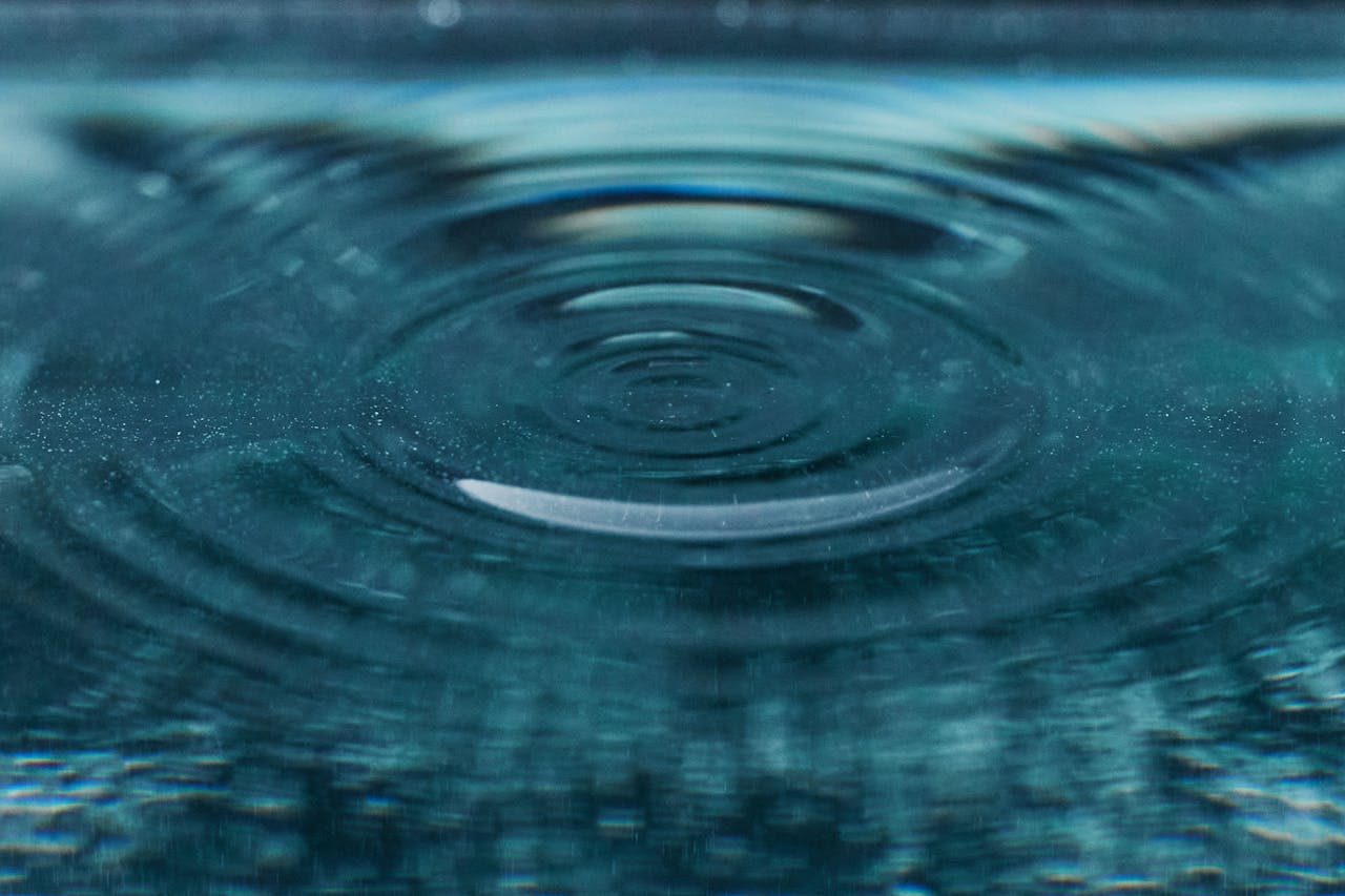 Beautiful detailed view of a ripple expanding on a blue water surface, capturing texture and motion.
